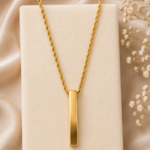 Man wearing a gold-tone vertical bar pendant necklace with rope chain and minimalist design.
